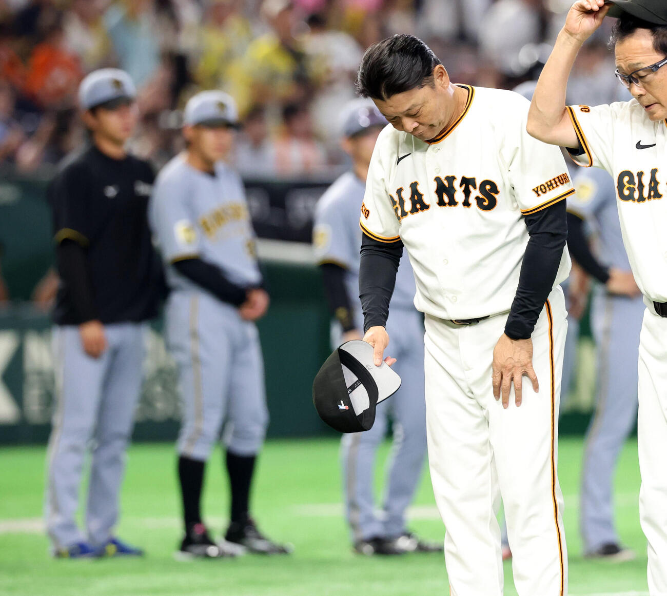 巨人対阪神　連敗に脱帽して一礼する巨人橋上秀樹監督代行（右）。後方左は阪神高橋遥人（撮影・浅見桂子）