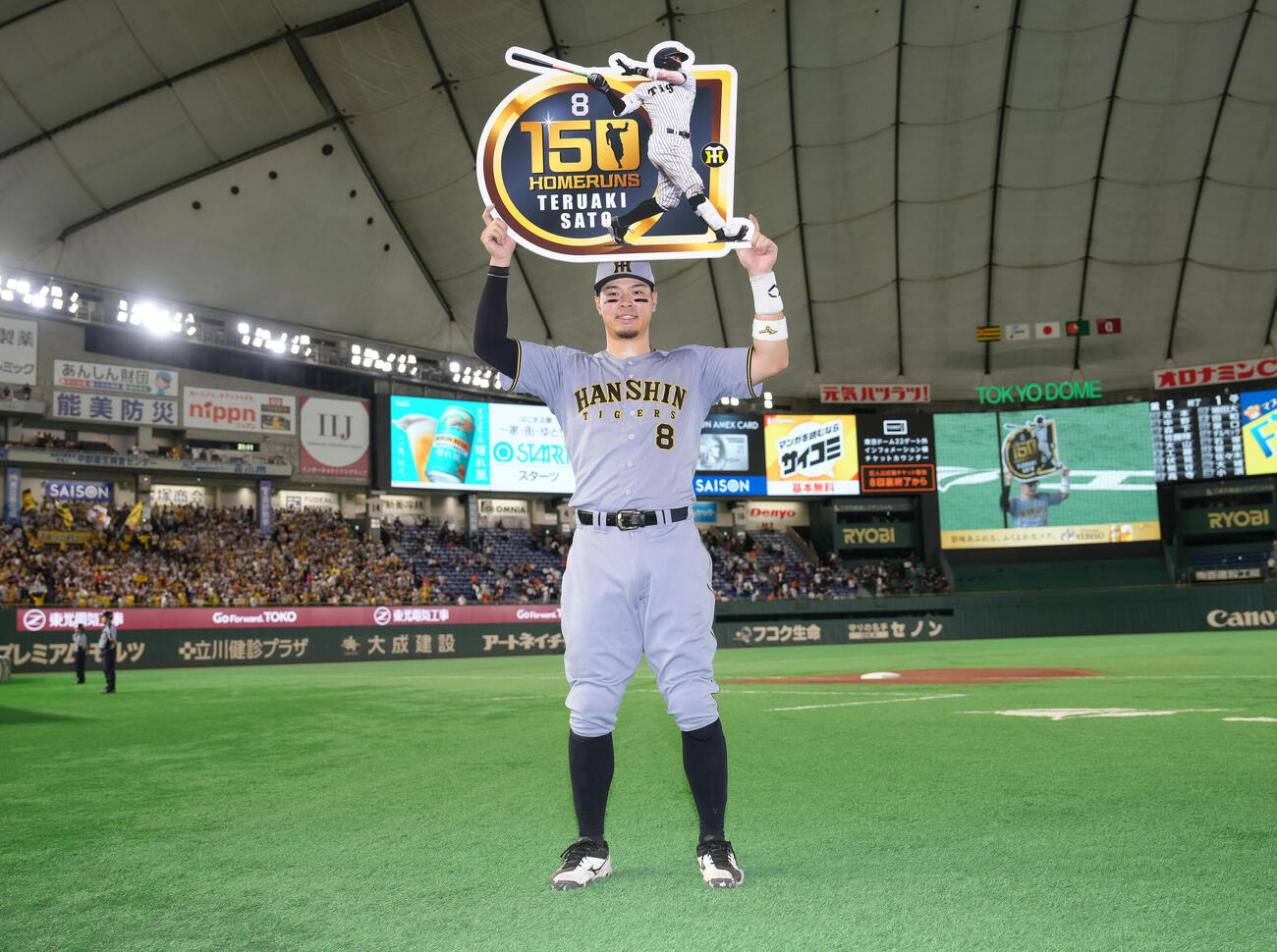 巨人対阪神　通算150号本塁打の記念ボードを掲げる阪神佐藤輝明（撮影・足立雅史）