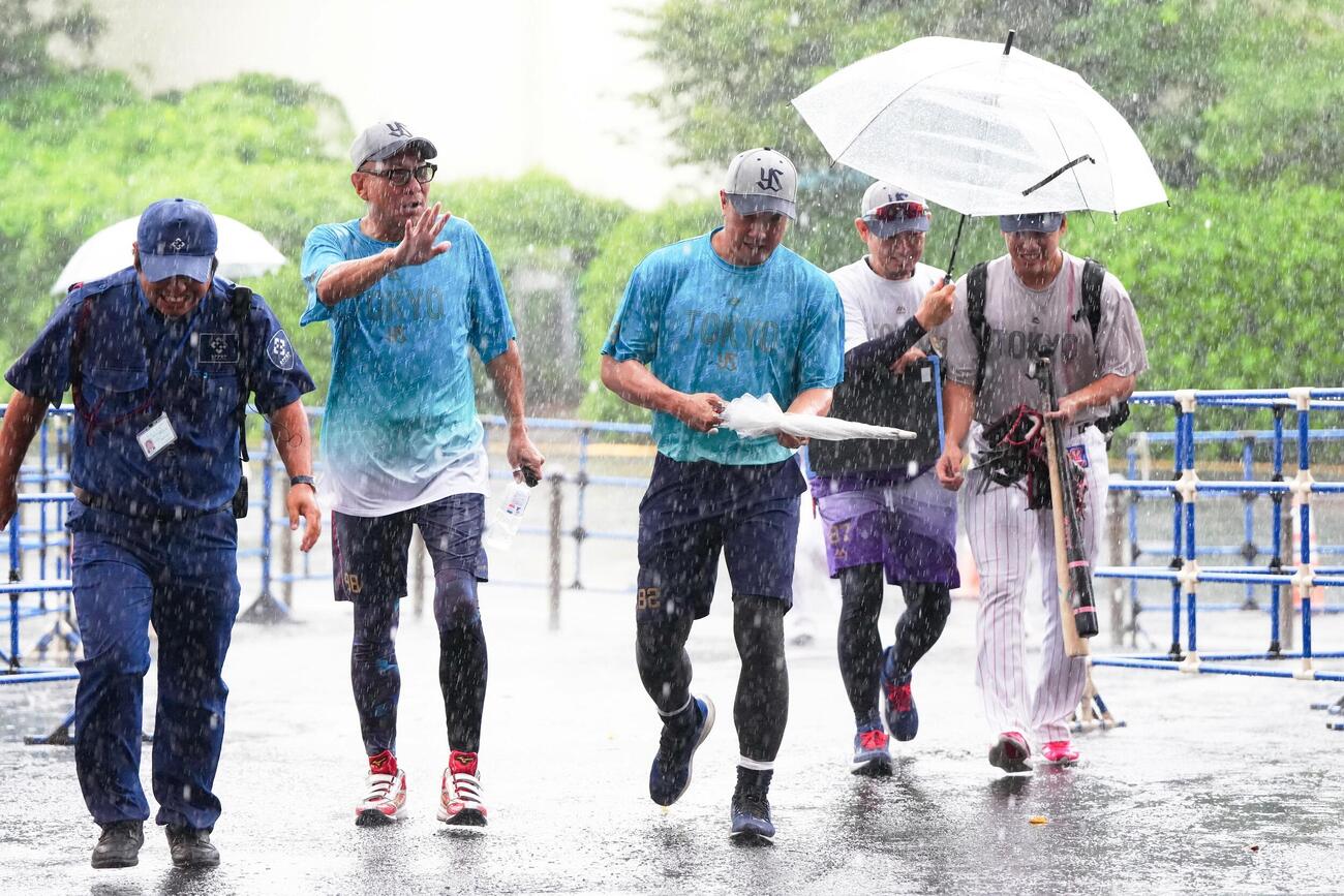 ヤクルト対広島　試合前、雨の中、室内練習場から移動するヤクルト池山隆寛監督（左から2人目）ら（撮影・江口和貴）