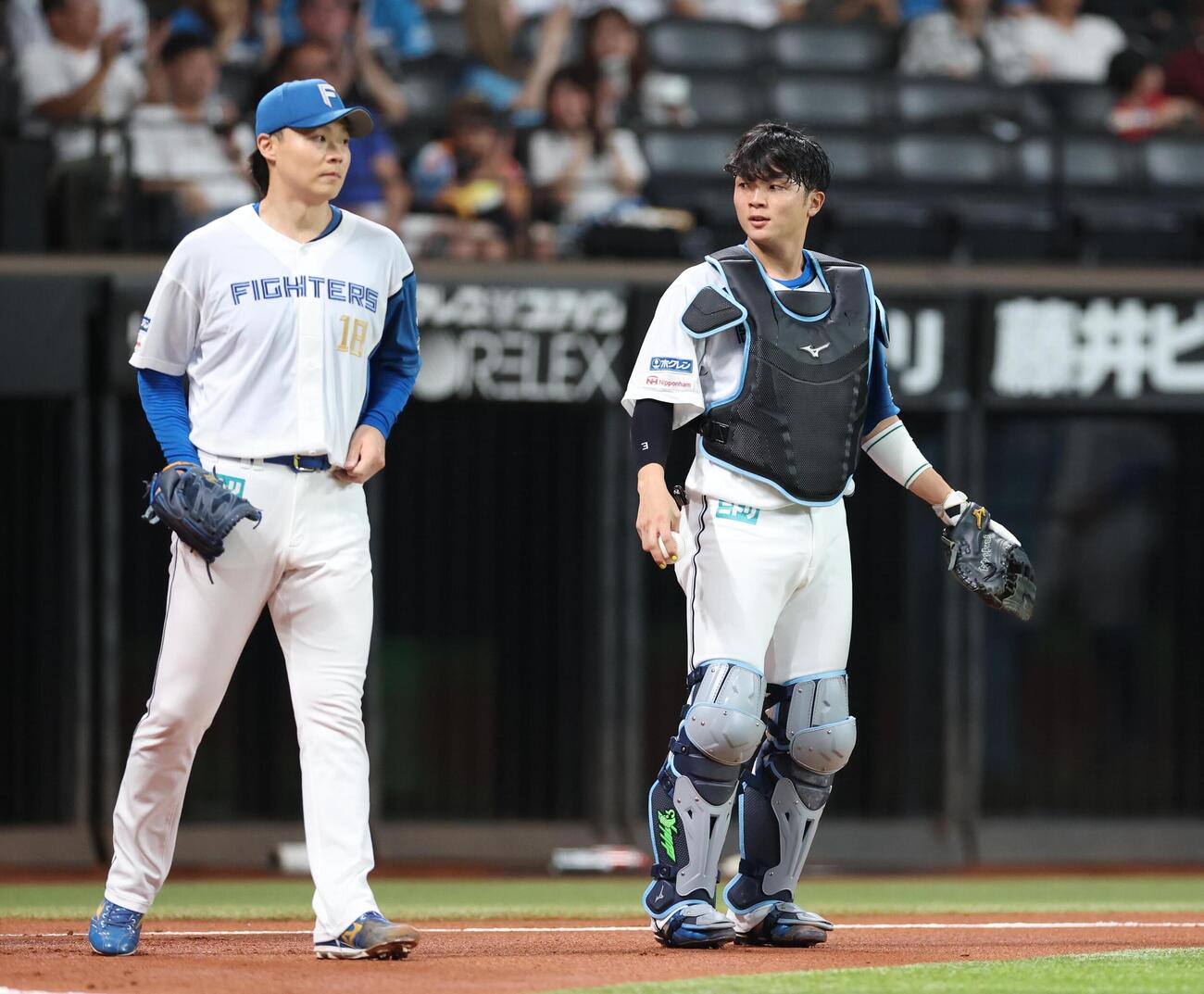 日本ハム対西武　2回表、言葉を交わす山崎福也（左）と郡司裕也（撮影・黒川智章）