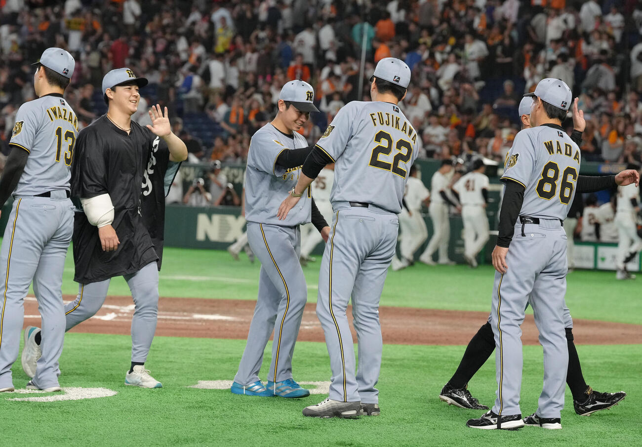 巨人対阪神　プロ初勝利を挙げた阪神下村海翔（中央左）は藤川球児監督（同右）とタッチを交わす（撮影・足立雅史）