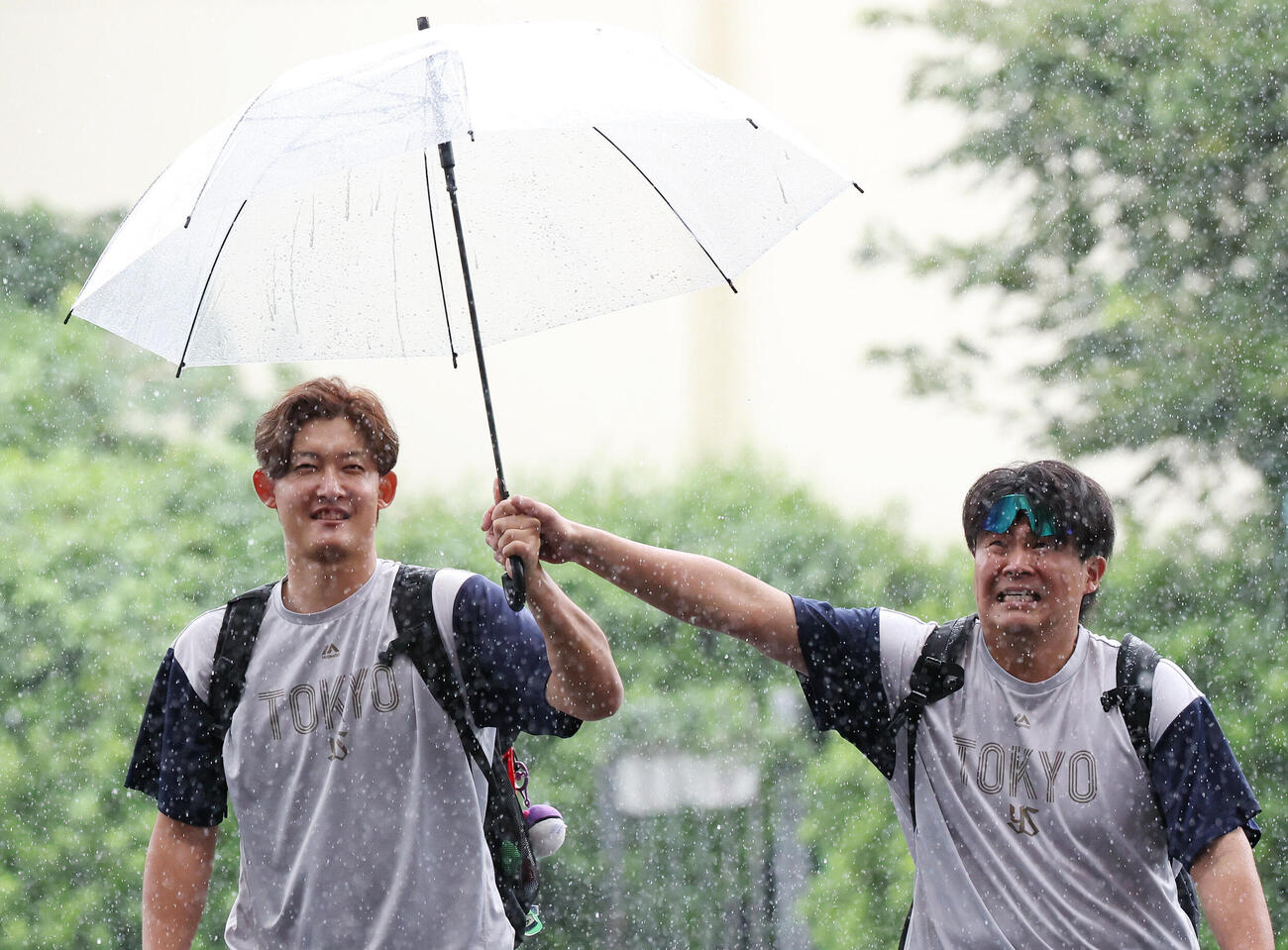 ヤクルト対DeNA　雨の中、練習場から移動するヤクルト阪口皓亮（左）と清水昇（撮影・宮地輝）
