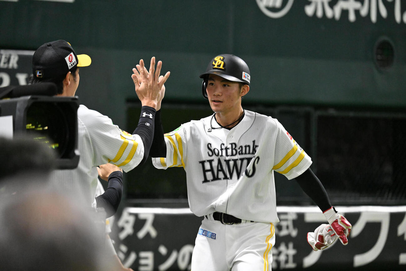 ソフトバンク対楽天　5回裏ソフトバンク2死一、二塁、近藤健介の先制適時打で生還した庄子雄大（右）はナインとタッチを交わす（撮影・林敢治）