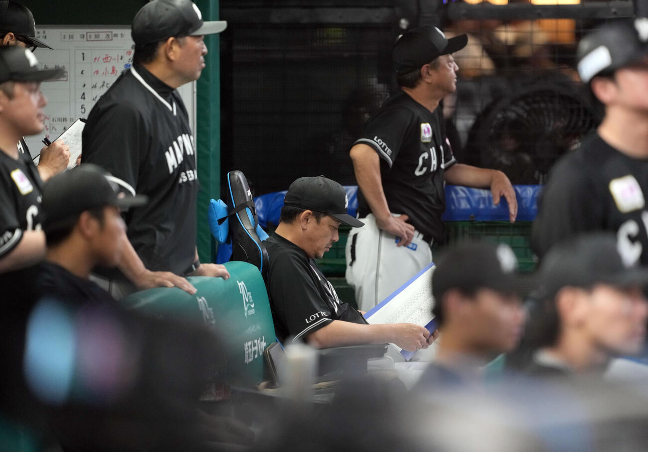 西武対ロッテ　ベンチで資料に目を通すロッテサブロー監督（撮影・たえ見朱実）