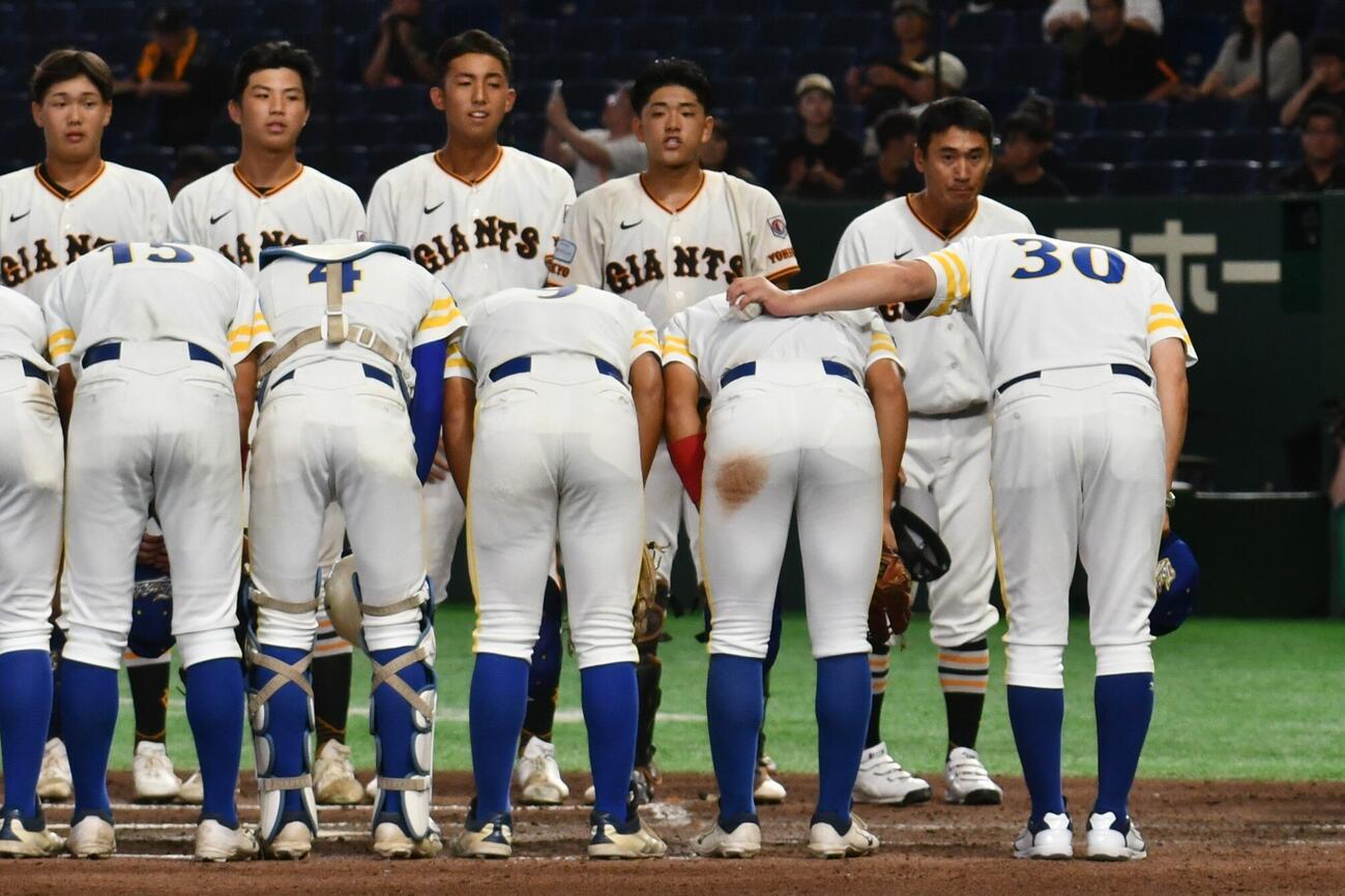 決勝が終わり、両チームが整列すると、取手の石崎監督（手前右端）は労うようにウイニングボールを持った左手を三ツ井主将の肩に回した。奥の列の右端は多摩川の片岡監督