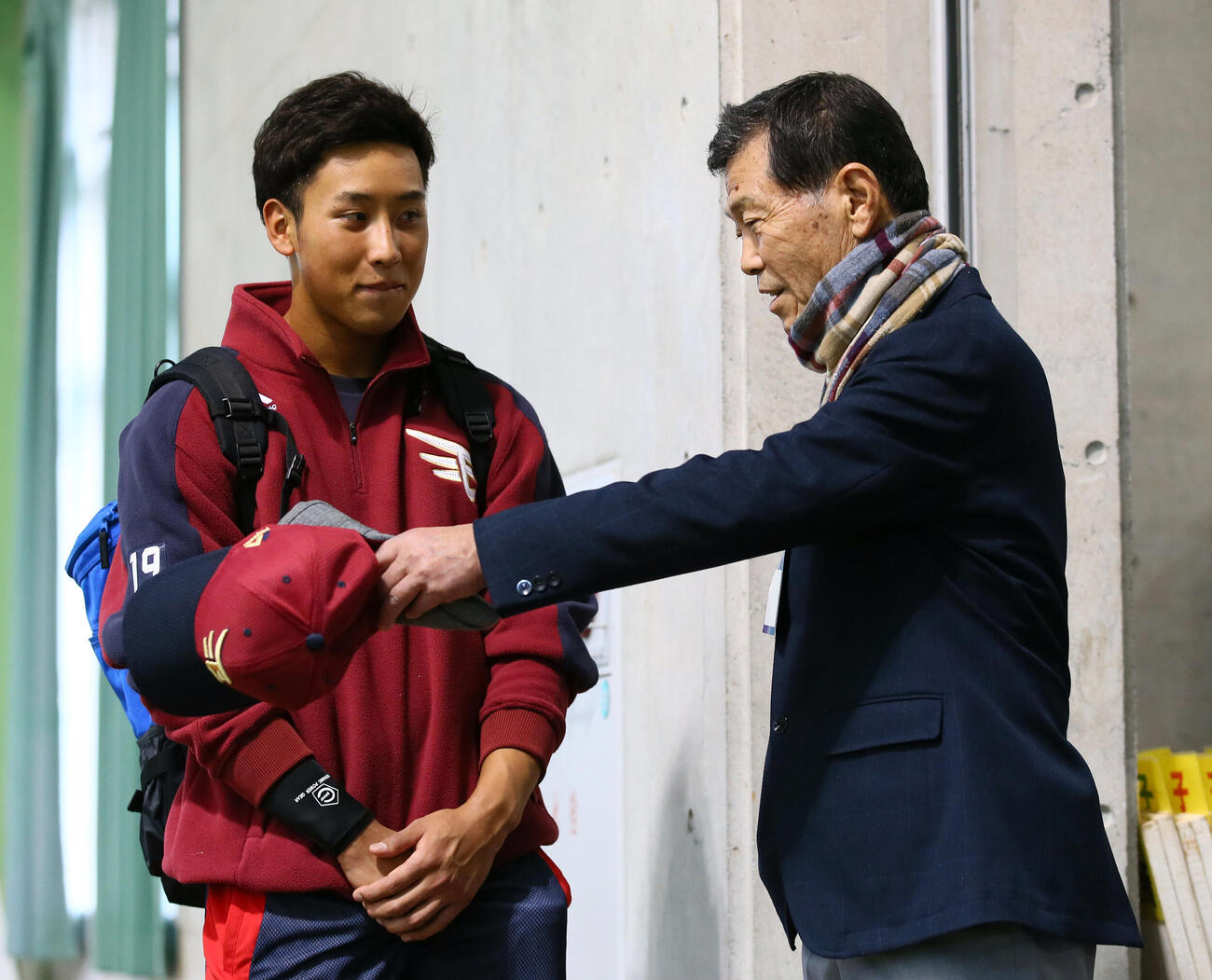 楽天藤平（左）はキャンプに訪れた横浜高前監督の渡辺氏の話に笑顔を見せる（2019年2月撮影）