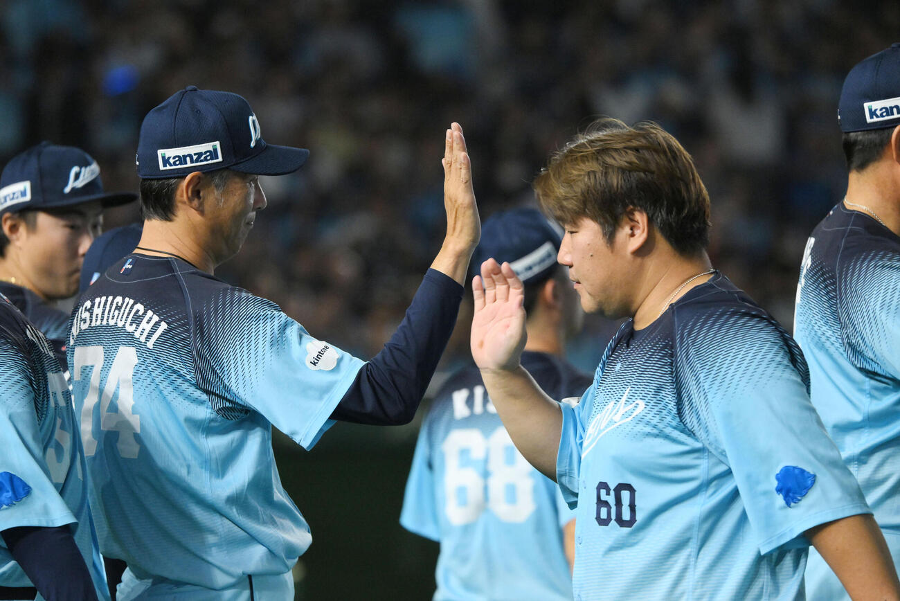 西武対オリックス　試合に勝利し選手を迎える西武西口文也監督（左）（撮影・滝沢徹郎）