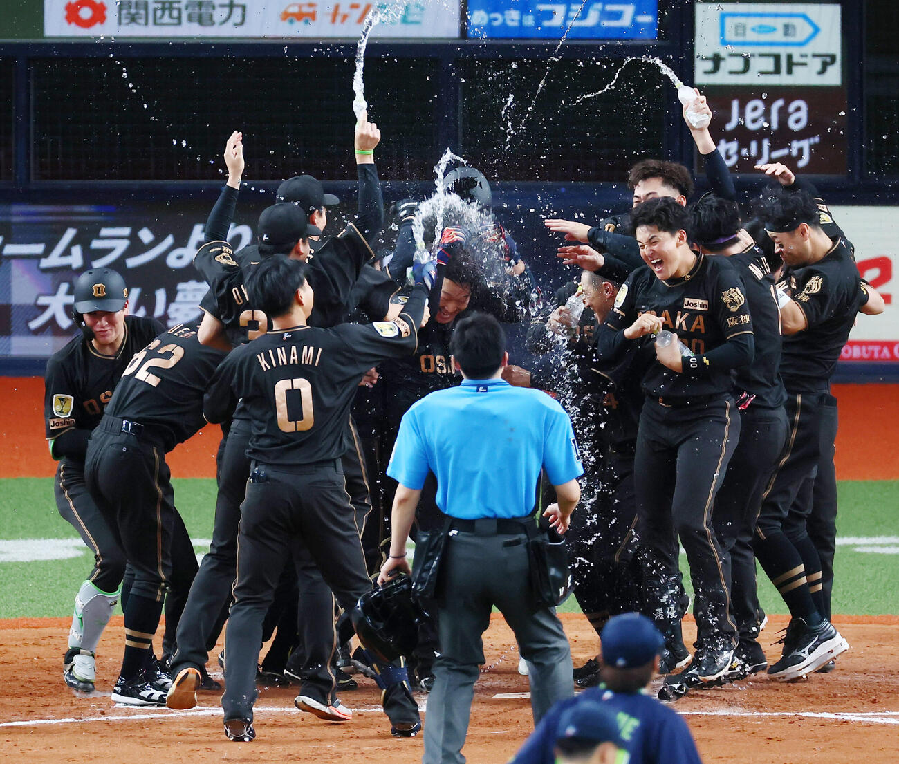阪神対ヤクルト　9回裏阪神1死、大山悠輔（中央）は左越えサヨナラソロ本塁打を放ちナインからのウオーターシャワーを受ける（撮影・加藤哉）