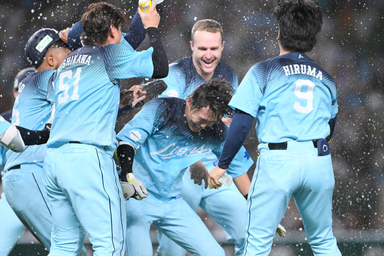 西武対オリックス　9回裏西武2死一、二塁、サヨナラ打を放った源田壮亮（中央）はウオーターシャワーで祝福される（撮影・滝沢徹郎）