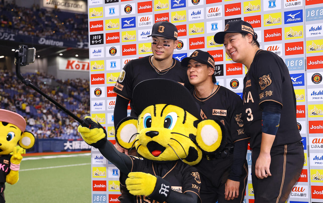 阪神対ヤクルト　トラッキーと記念撮影をする阪神の、左から佐藤輝明、植田海、大山悠輔（撮影・上田博志）