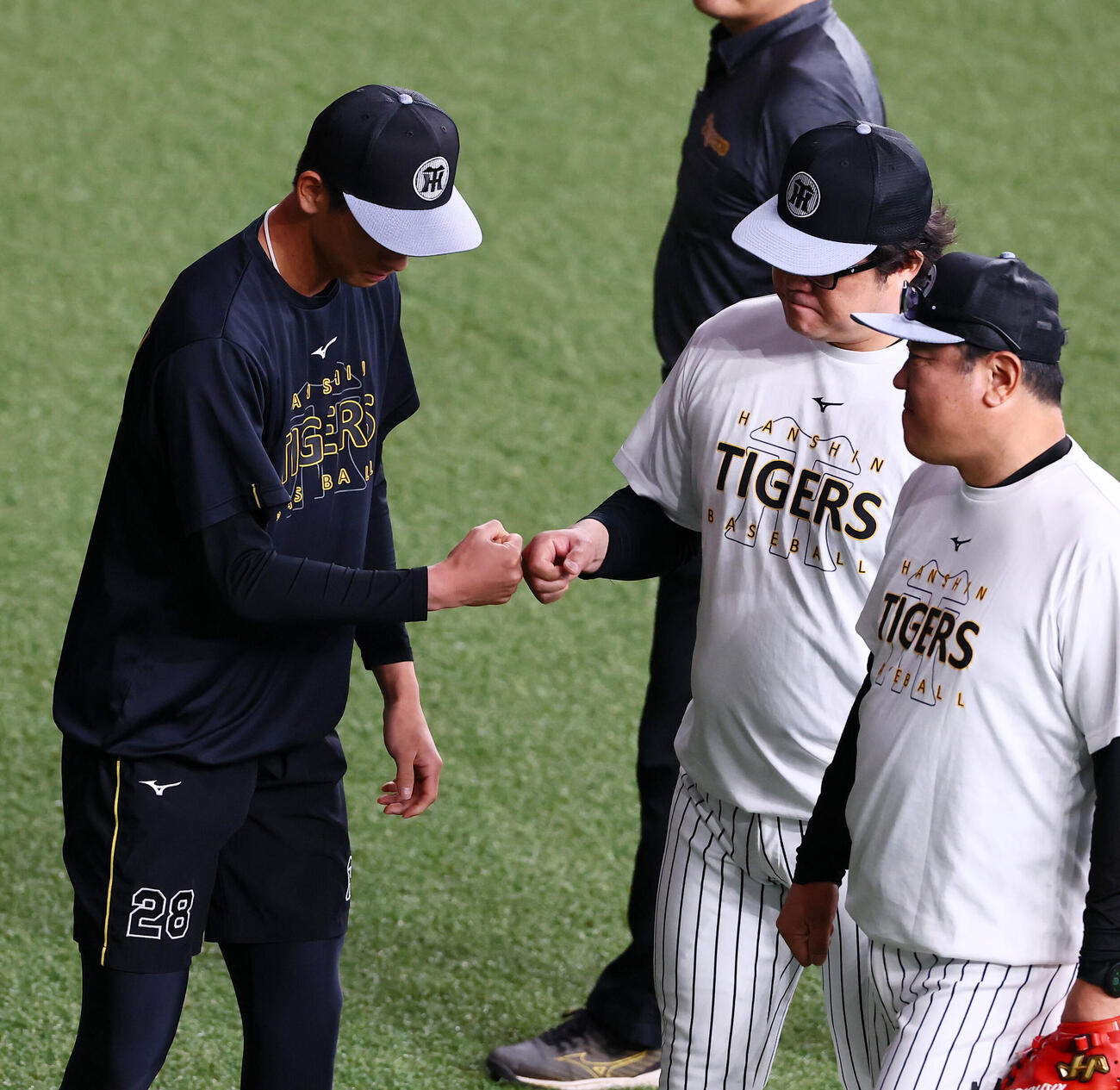 阪神対ヤクルト　練習中、安藤優也コーチ（中央）とグータッチする阪神今朝丸裕喜（撮影・加藤哉）