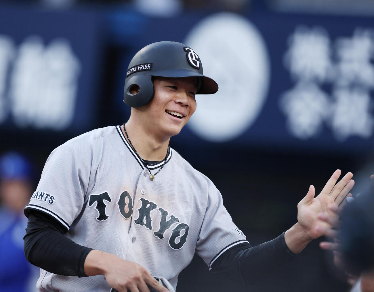 DeNA対巨人　1回表巨人1死一、三塁、泉口友汰の二盗の間に生還しナインとタッチを交わす佐々木俊輔（撮影・増田悦実）