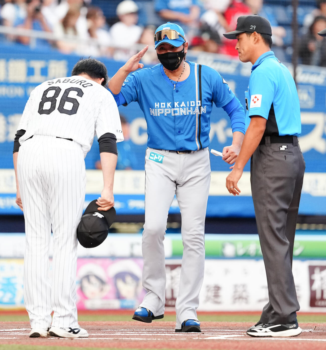 ロッテ対日本ハム　メンバー表最終確認に臨むロッテのサブロー監督（手前）と日本ハム新庄剛志監督（後方）（撮影・鈴木みどり）