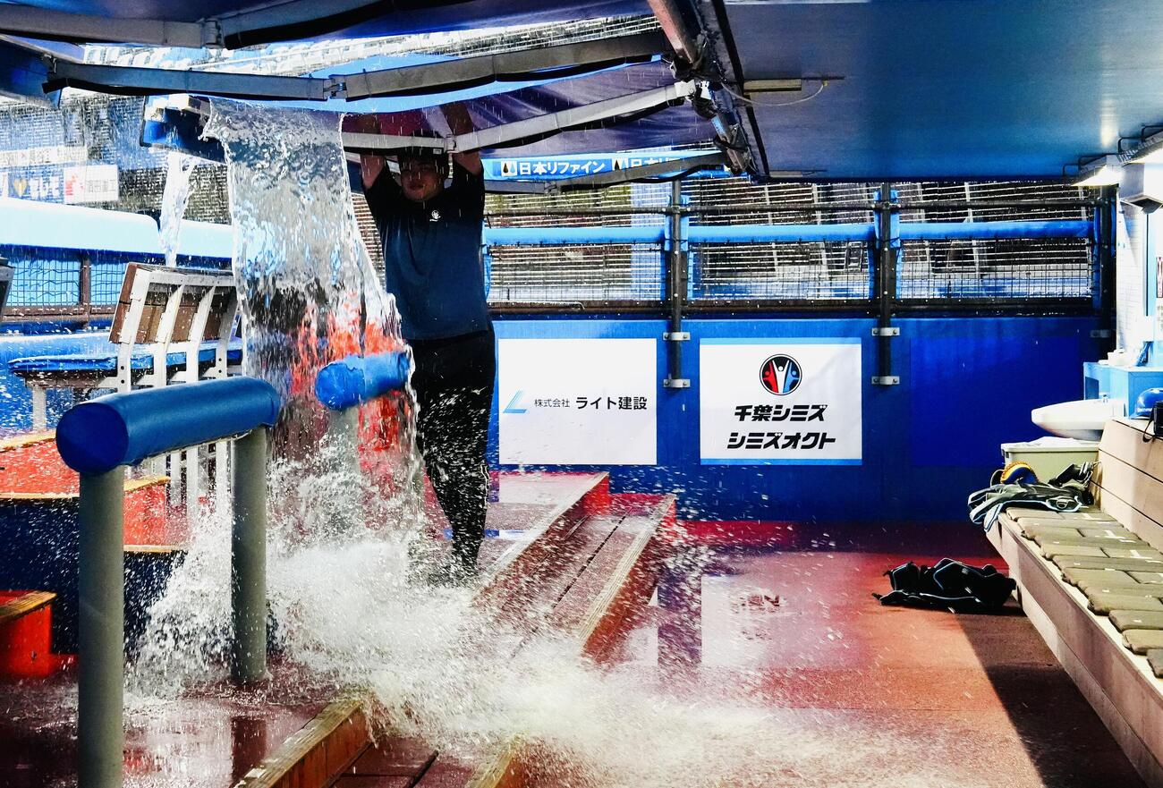 ロッテ対日本ハム　試合前、日本ハムベンチの屋根にたまった雨水を落とすスタッフ（撮影・江口和貴）