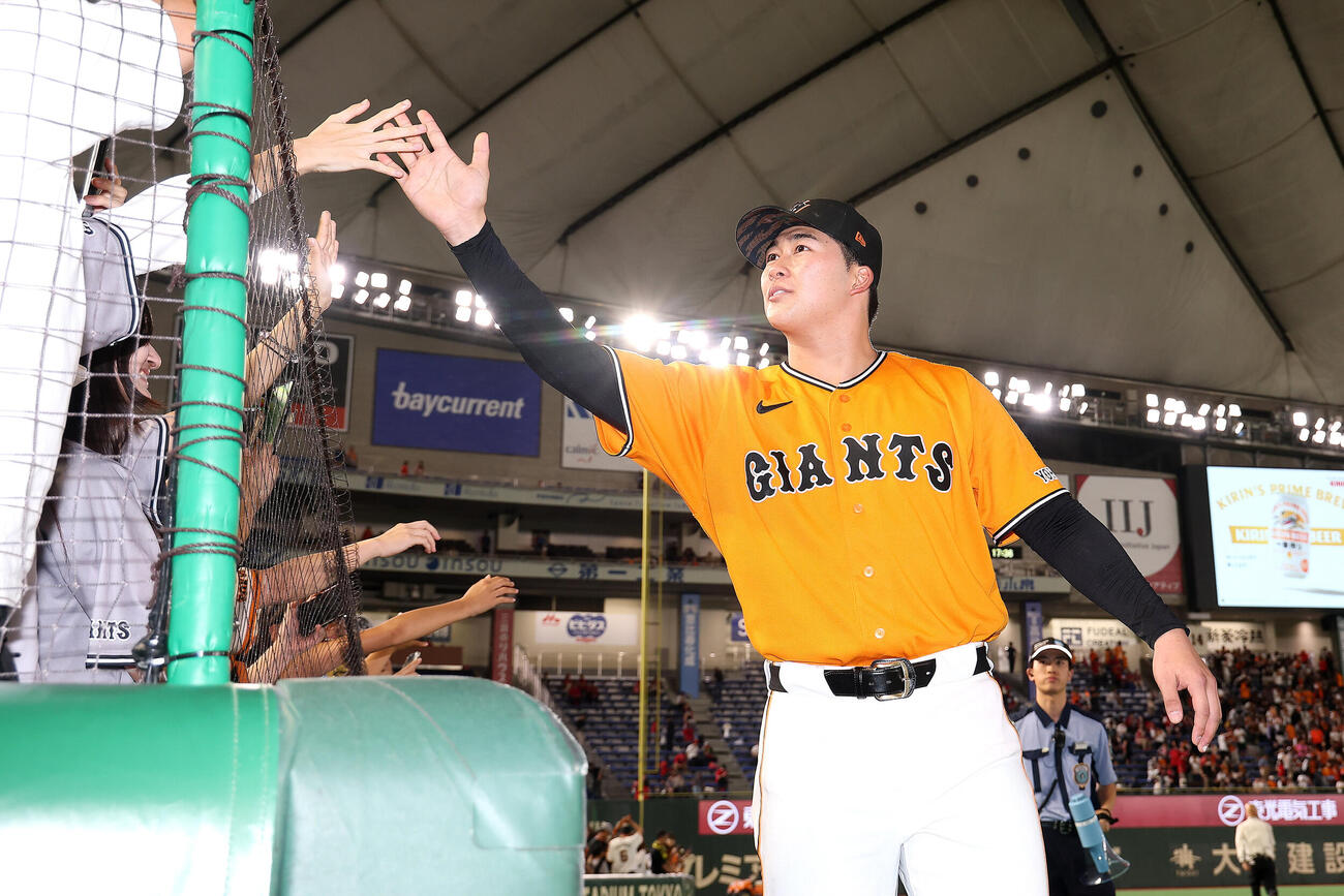 巨人対広島　プロ初勝利を飾り、ファンとタッチを交わす巨人代木大和（撮影・河田真司）