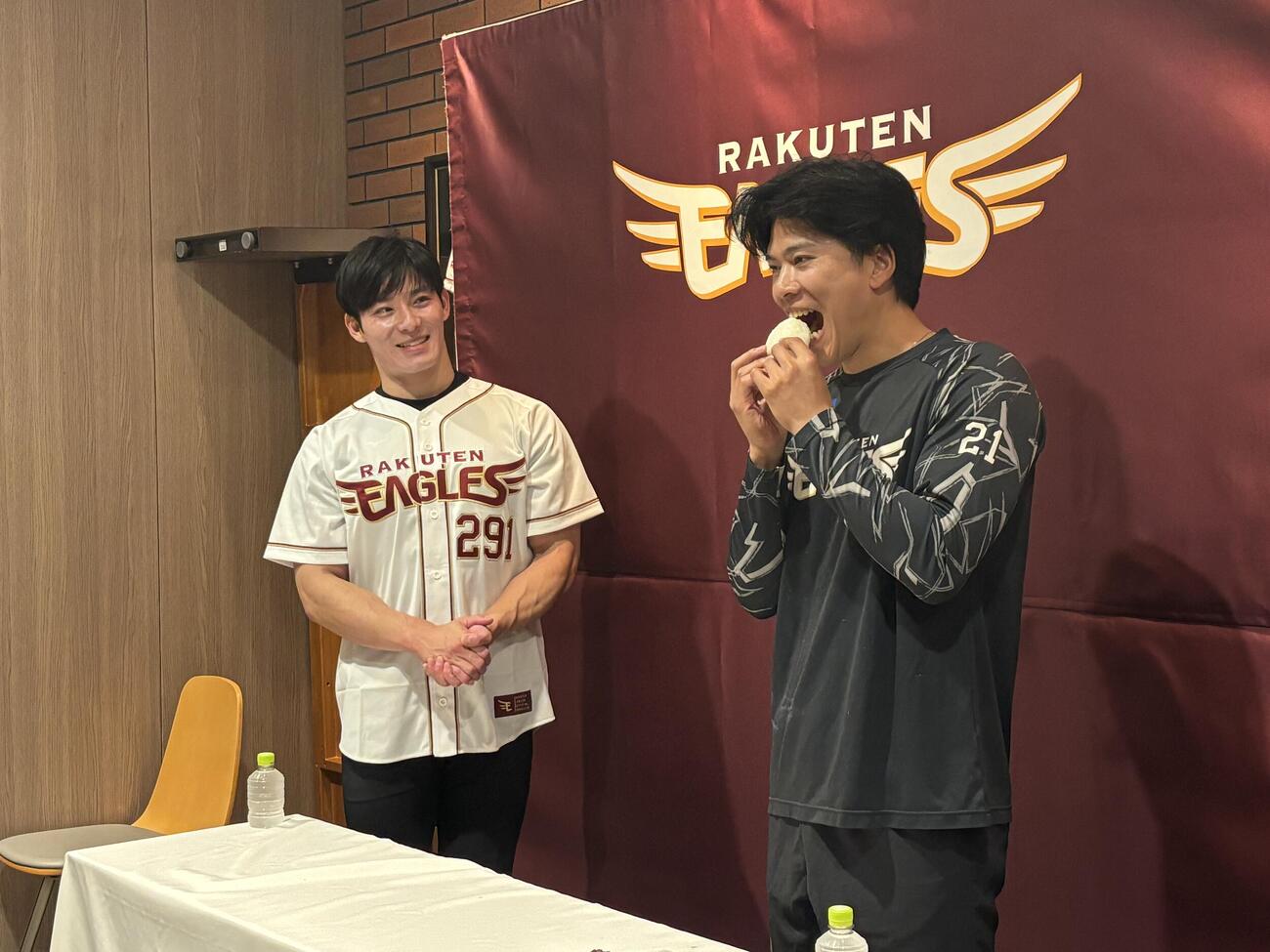 「いちほまれ」の贈呈式に出席し、おにぎりを試食する楽天早川隆久。左は福井県の石田嵩人知事