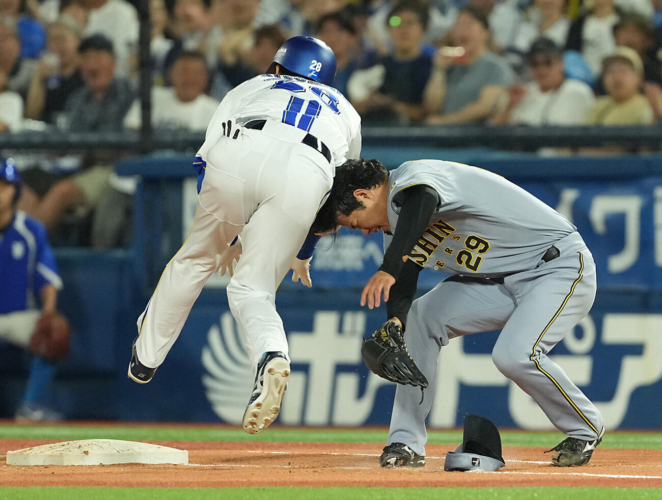 DeNA対阪神　4回裏DeNA2死満塁、勝又温史の打球をファンブルした高橋遥人は、接触し倒れ込む（撮影・たえ見朱実）