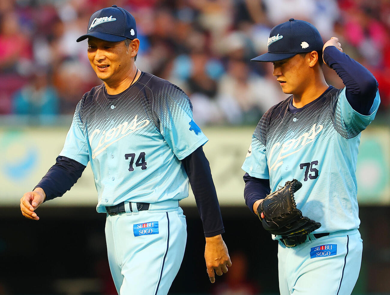楽天対西武　6回裏楽天2死一塁、降板する先発佐藤爽（右）と話しながらベンチに戻る西武西口文也監督（撮影・野上伸悟）