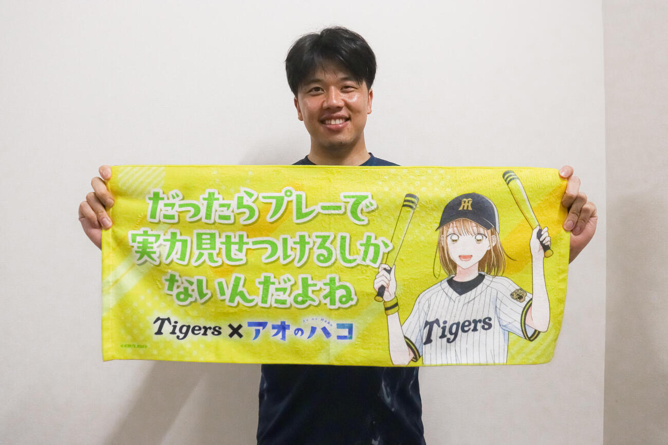 テレビアニメ『アオのハコ』とのコラボグッズを持つ才木浩人（球団提供）