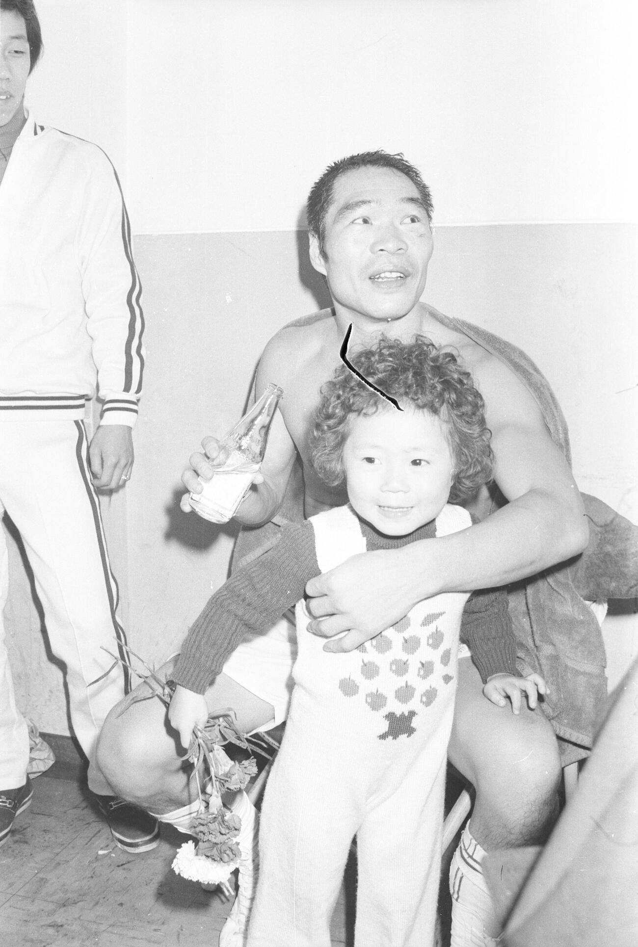 5度目の防衛を果たし、長女有紀ちゃん（のちタレント鈴木佑季）を抱きホッとした表情（75年12月撮影）