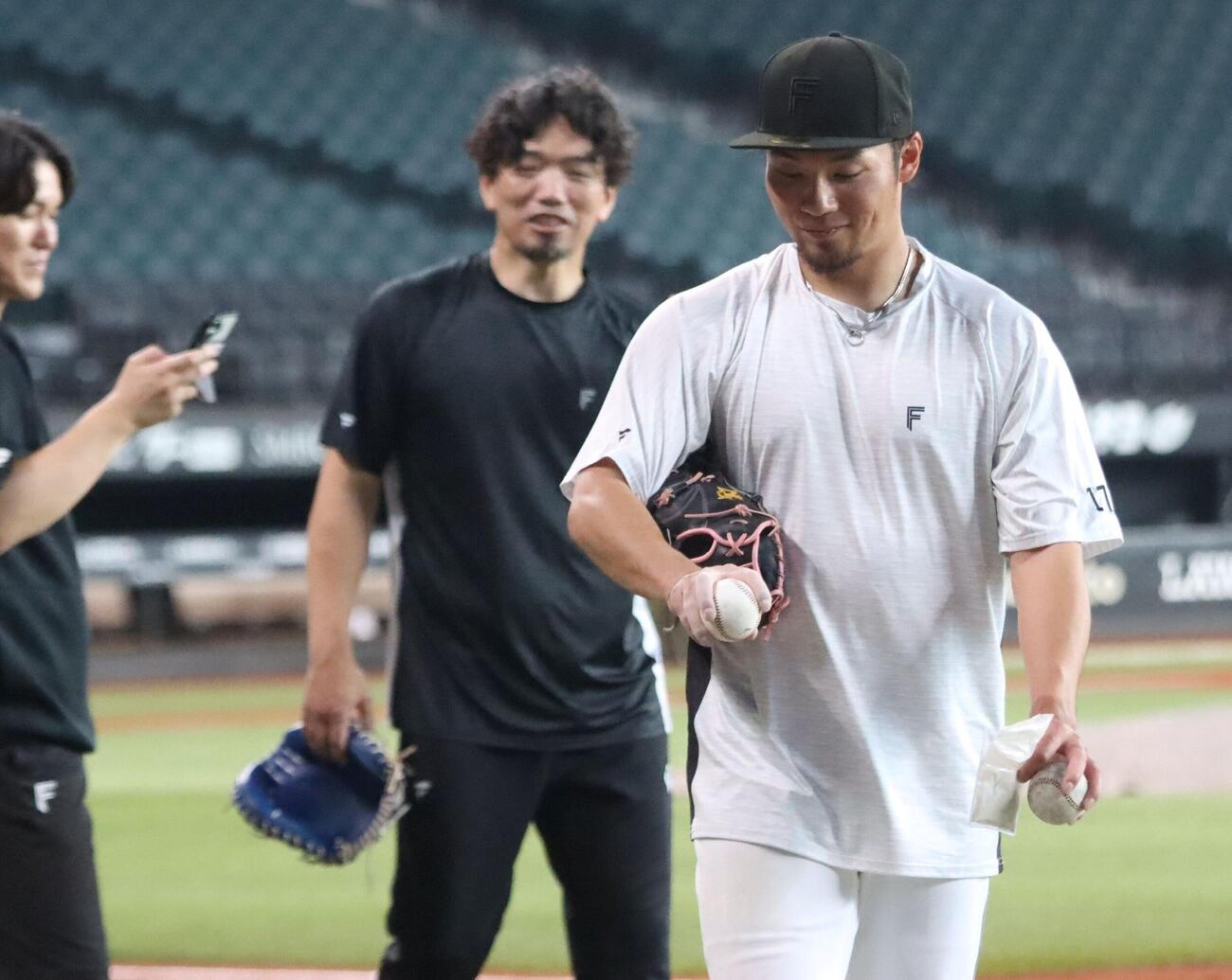 ボールの握りを確認する日本ハム伊藤