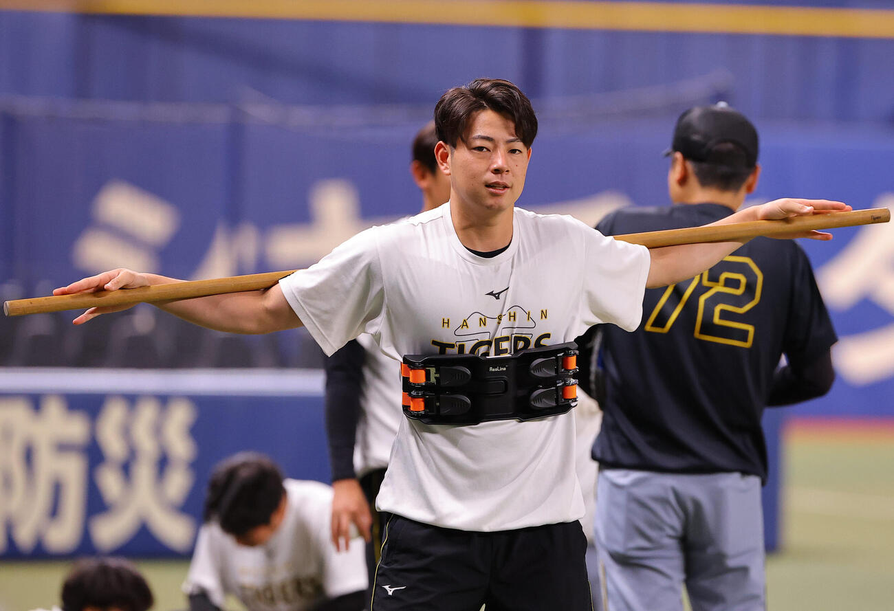 中日対阪神　器具を使ってストレッチをする下村海翔（撮影・上田博志）