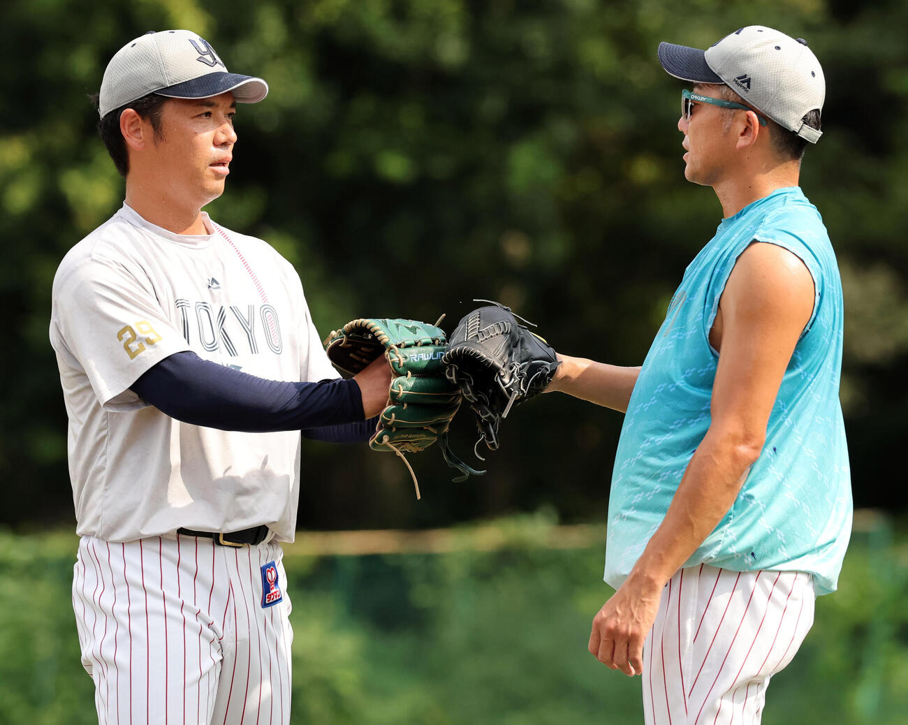 ヤクルト対巨人　キャッチボールを終え、グラブタッチするヤクルト小川泰弘（左）と石川雅規（撮影・浅見桂子）