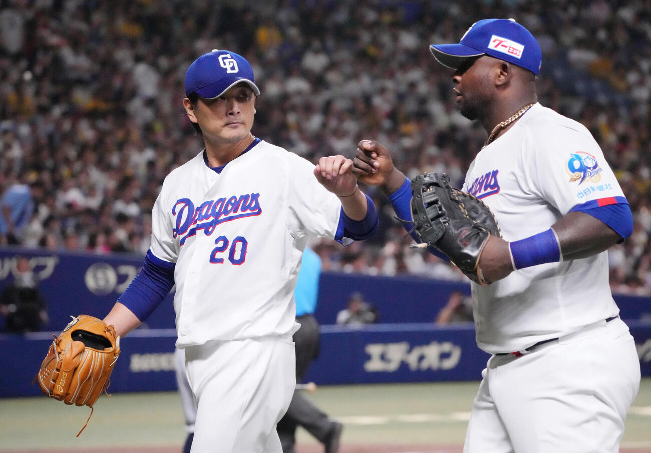 中日対阪神　3回表終了、中日先発の涌井秀章（左）はミゲル・サノーとタッチを交わしながらベンチへ戻る（撮影・森本幸一）