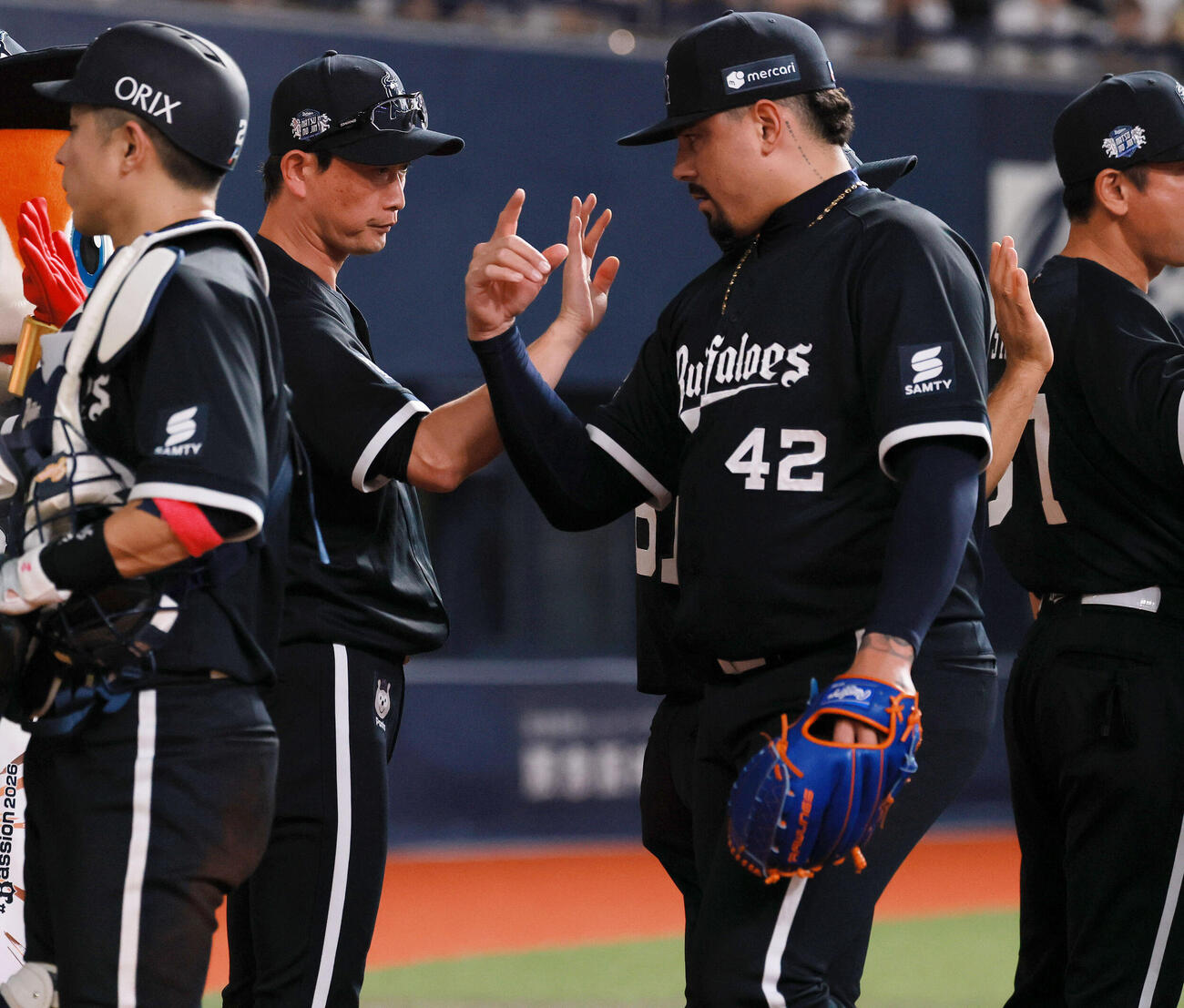 オリックス対楽天　楽天に勝利したオリックス岸田護監督（左から2人目）はベンチ前でナインとタッチをかわす（撮影・上山淳一）