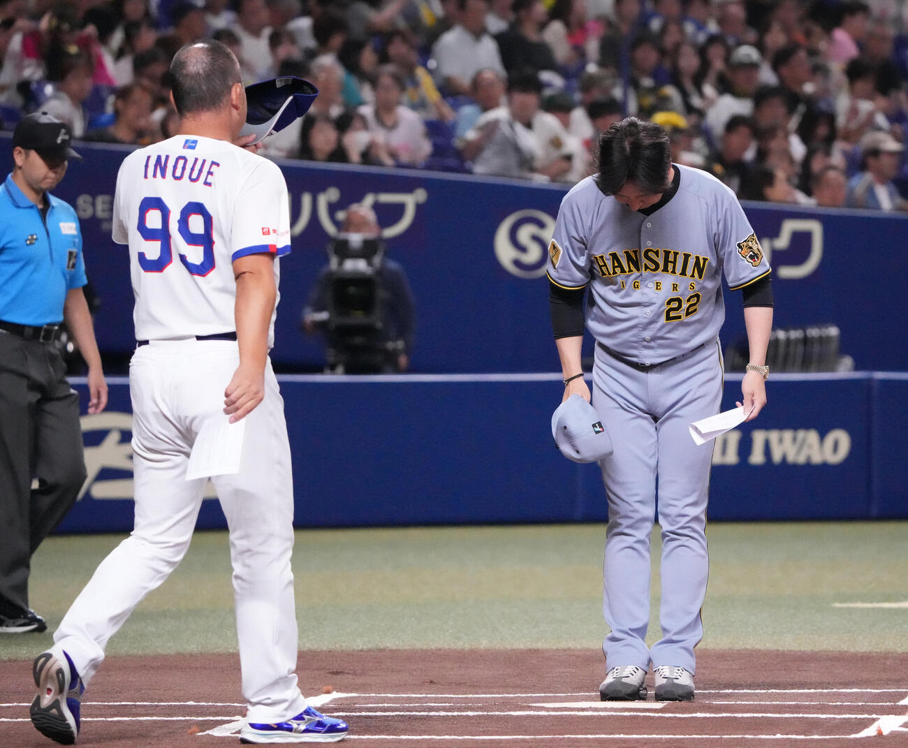 中日対阪神　試合前、藤川球児監督（右）は井上一樹監督、審判団らとメンバー表交換を行う（撮影・森本幸一）