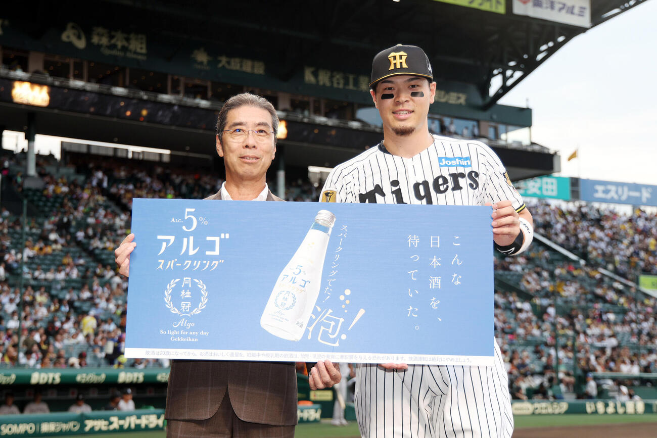 阪神対巨人　試合前、日刊スポーツ新聞社後援「阪神タイガース激励シリーズ」で最優秀選手の表彰を受ける阪神佐藤輝明（右）（撮影・前田充）