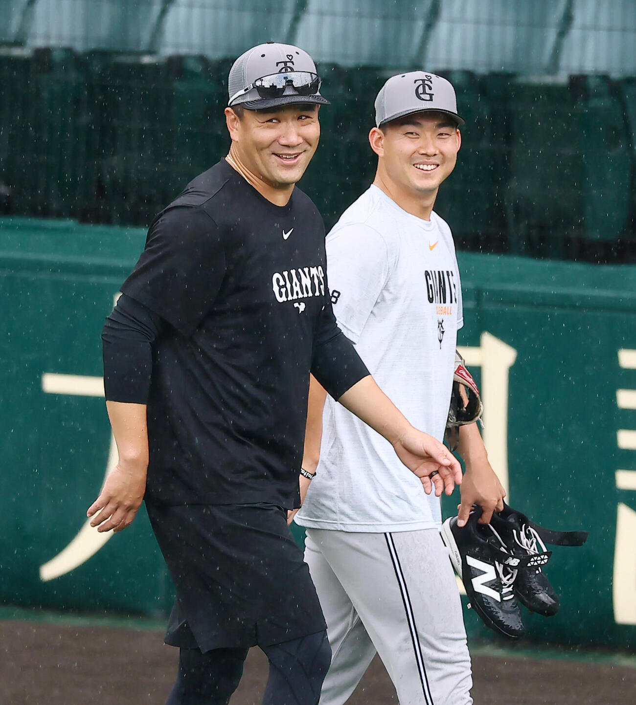 阪神対巨人　雨の中マウンドを確認し笑顔を見せる巨人田中将大（左）と小笠原慎之介（撮影・加藤哉）