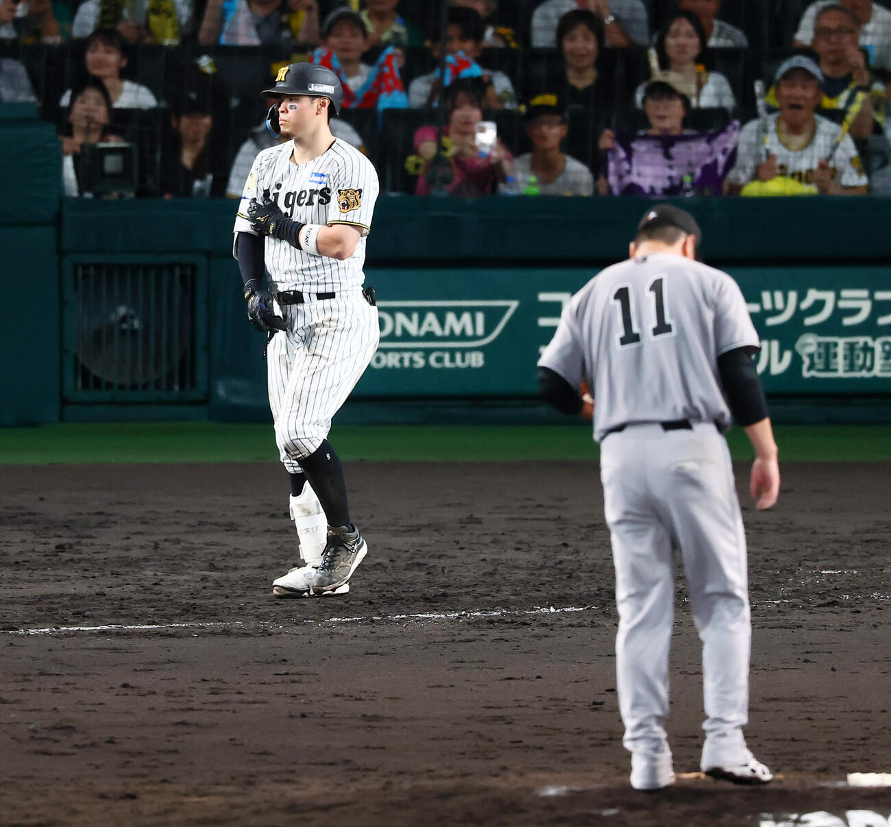 阪神対巨人　5回裏阪神2死三塁、申告敬遠され一塁へ向かう佐藤輝明。投手田中将大（撮影・加藤哉）