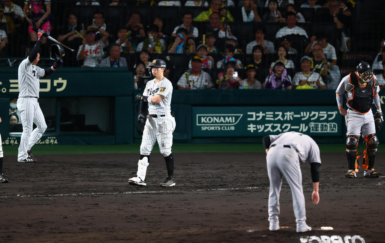阪神対巨人　5回裏阪神2死三塁、申告敬遠され一塁へ向かう佐藤輝明。投手田中将大（撮影・加藤哉）