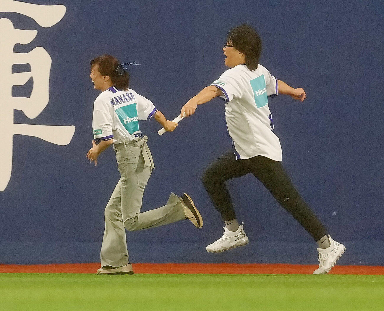 DeNA対中日　イニング間のリレー対決でバトンパスに失敗する相川七瀬（左）（撮影・足立雅史）