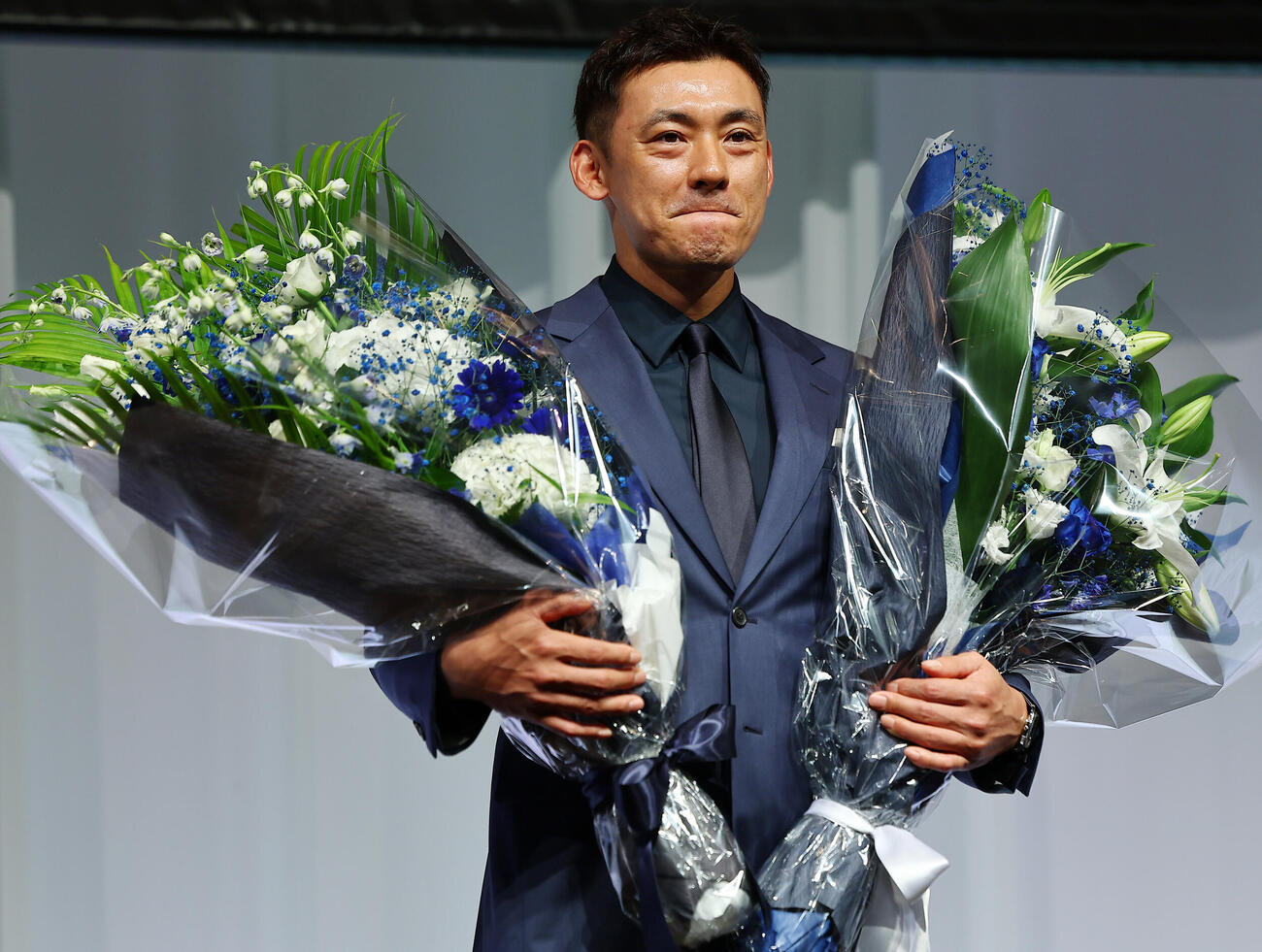 引退会見で、花束を手にする西武栗山巧（撮影・野上伸悟）
