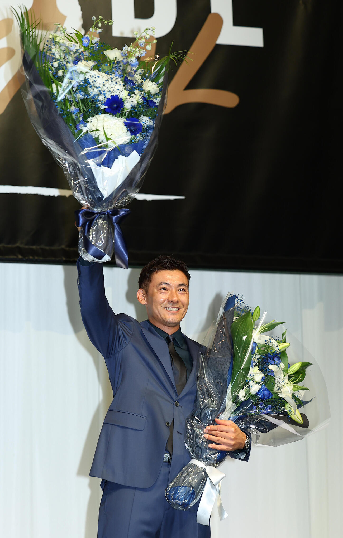 引退会見で、花束を手にする西武栗山巧（撮影・野上伸悟）