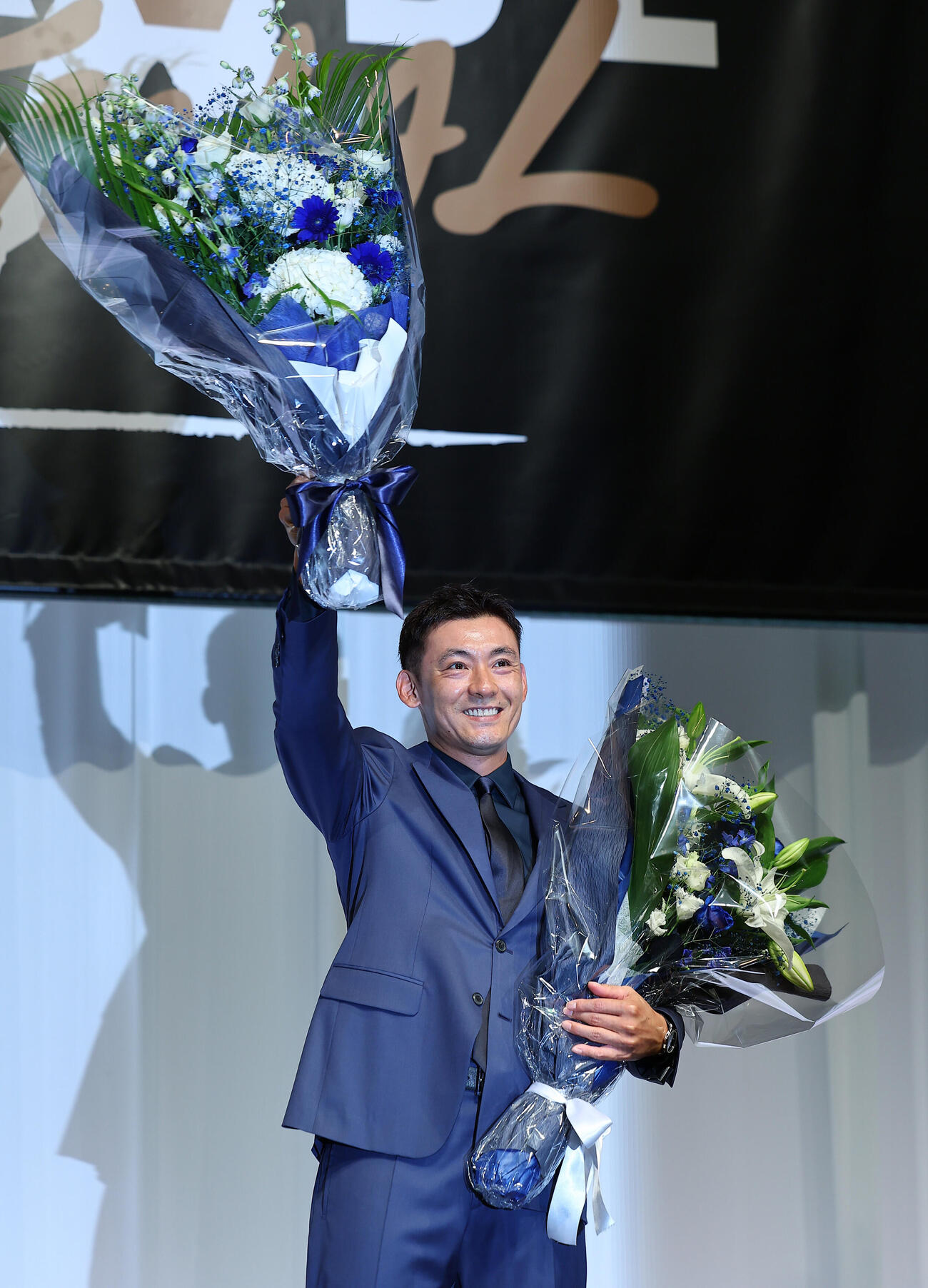 引退会見で、花束を手に笑顔を見せる西武栗山巧（撮影・野上伸悟）