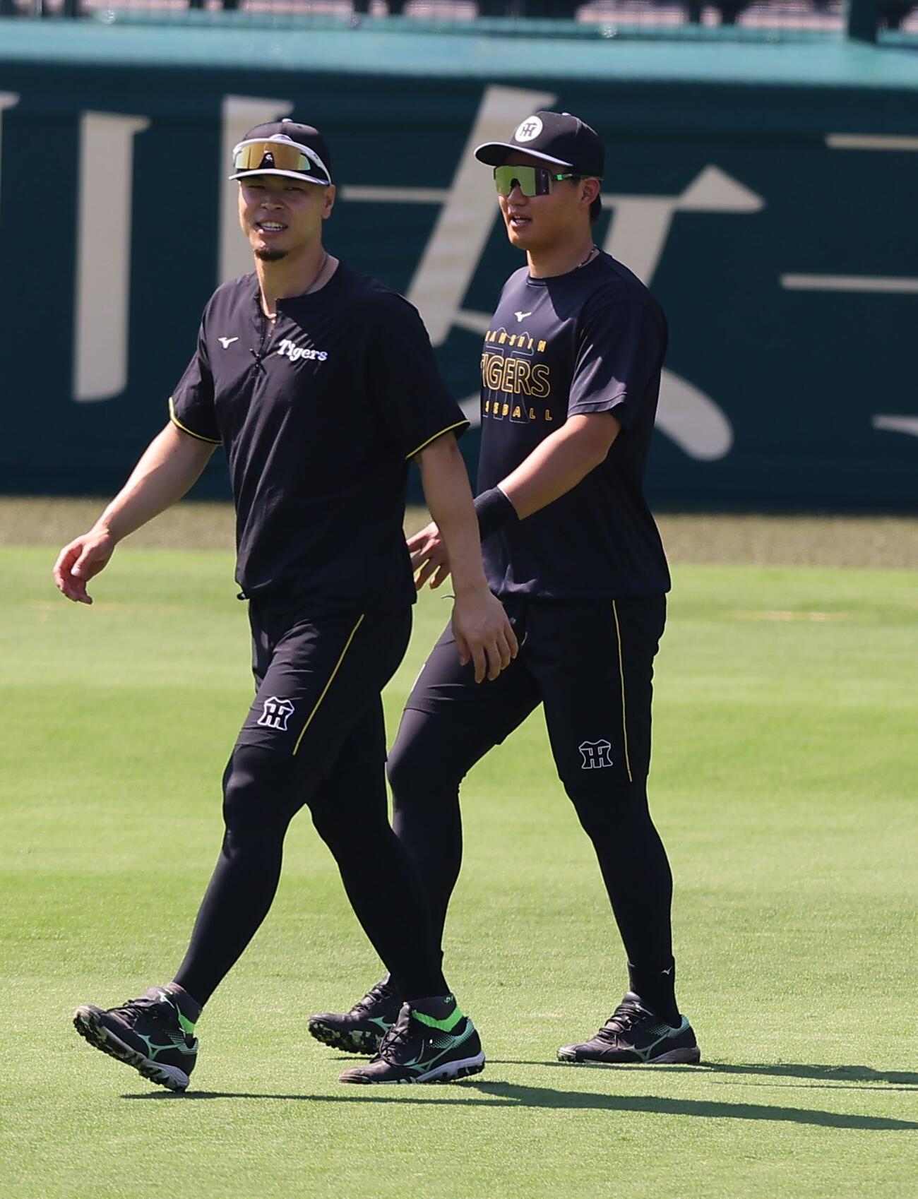 阪神対巨人　佐藤輝明（左）とグラウンドに入る森下翔太（撮影・上田博志）＝2026年8月30日、甲子園球場
