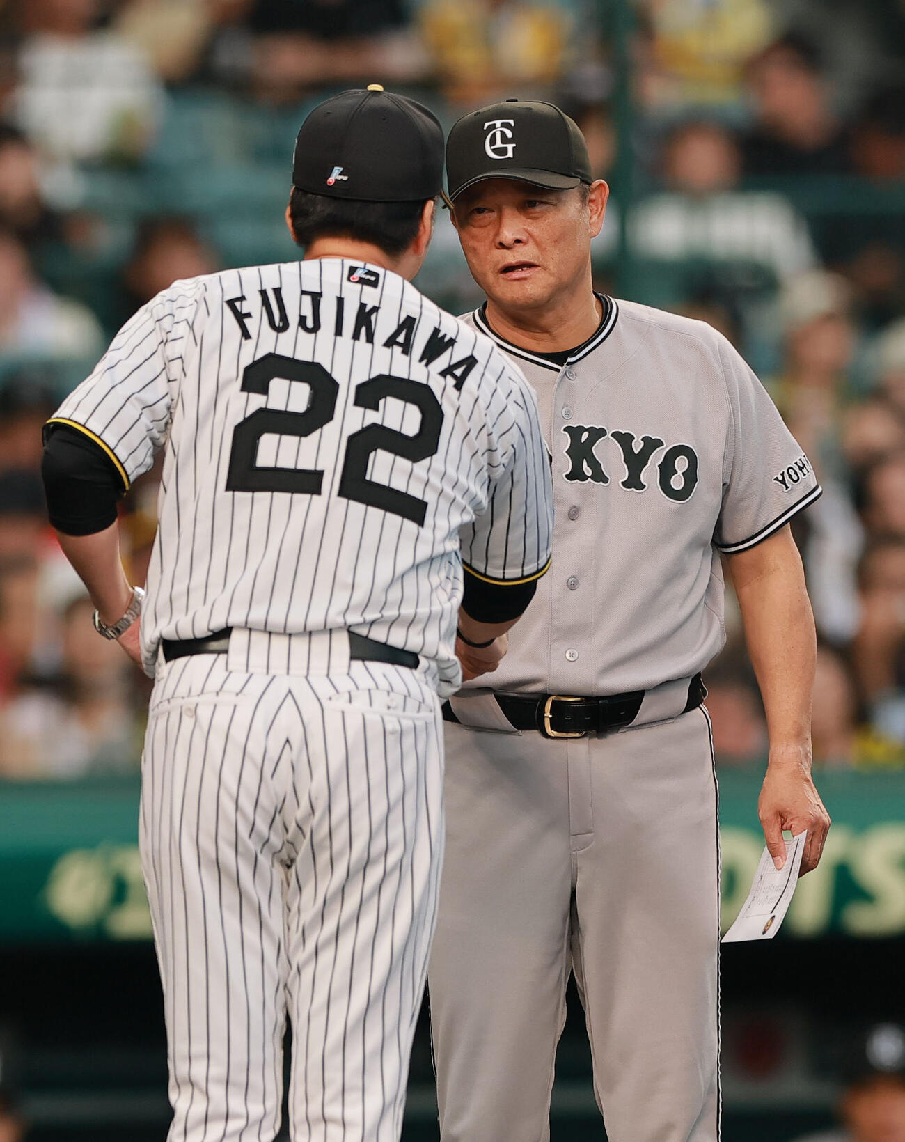 阪神対巨人　メンバー表の最終確認で言葉をかわす阪神藤川球児監督（手前）と巨人橋上秀樹監督代行（撮影・上山淳一）