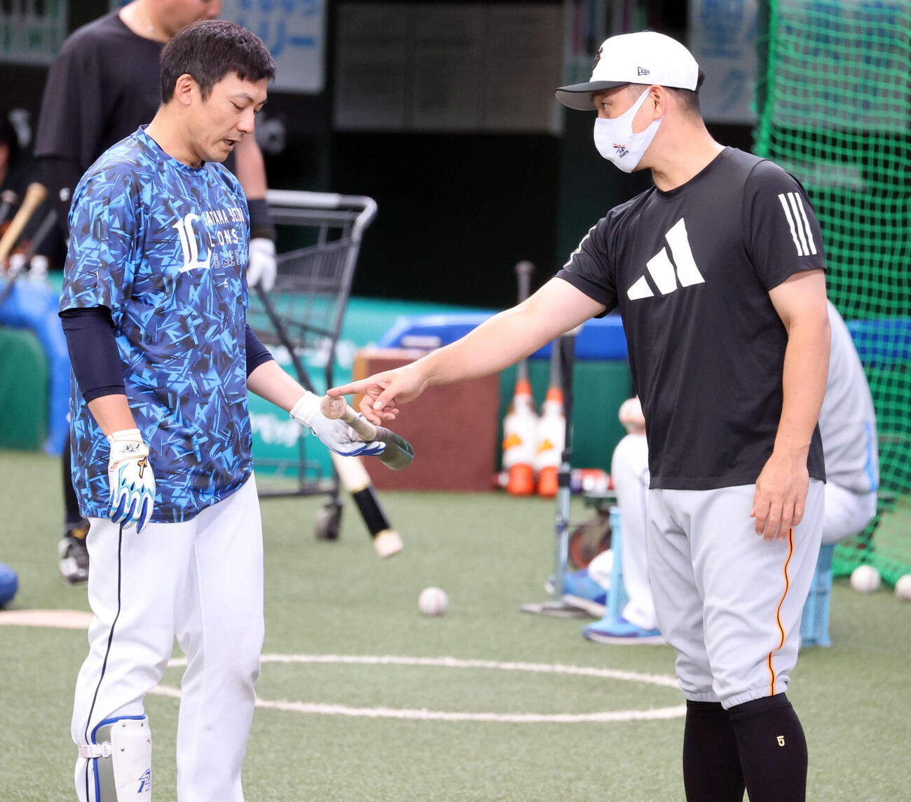 西武対巨人　試合前、巨人中島（右）と打撃談議する西武栗山（2022年6月撮影）