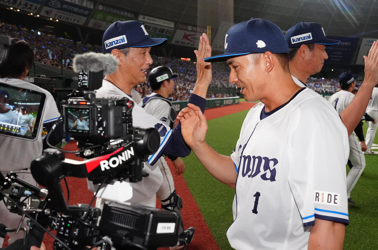 西武対楽天　試合後、西武西口文也監督（左）とタッチを交わす栗山巧（撮影・江口和貴）