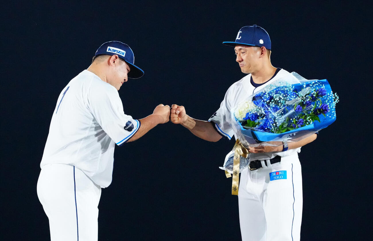 引退セレモニーで西武中村剛也（左）とタッチを交わす栗山巧（撮影・江口和貴）