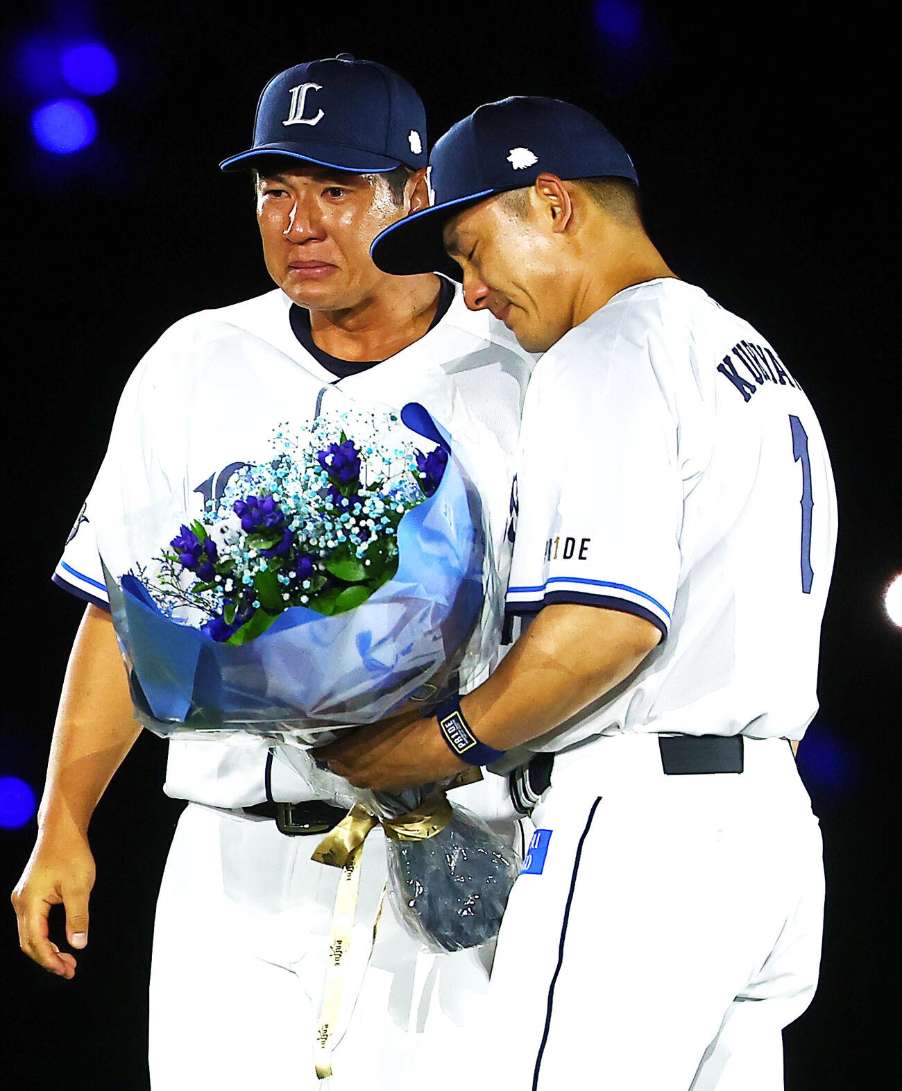 西武対楽天　栗山巧（右）の引退セレモニーで、涙ながらに花束を渡す炭谷銀仁朗（撮影・野上伸悟）