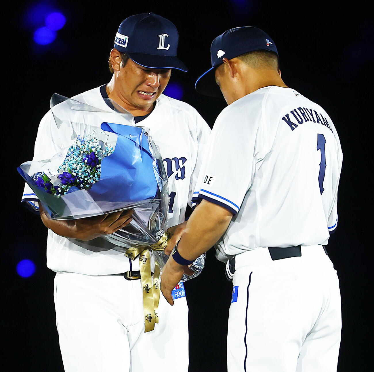 西武対楽天　栗山巧（右）の引退セレモニーで、涙ながらに花束を渡す炭谷銀仁朗（撮影・野上伸悟）