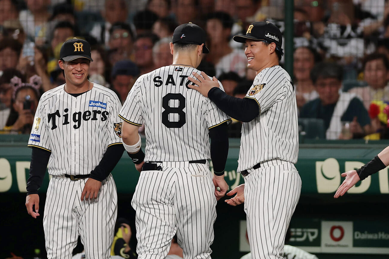 阪神対巨人　3回表の守備を終えた佐藤輝明（中央）らを笑顔で出迎える阪神森下翔太（右）（撮影・前田充）