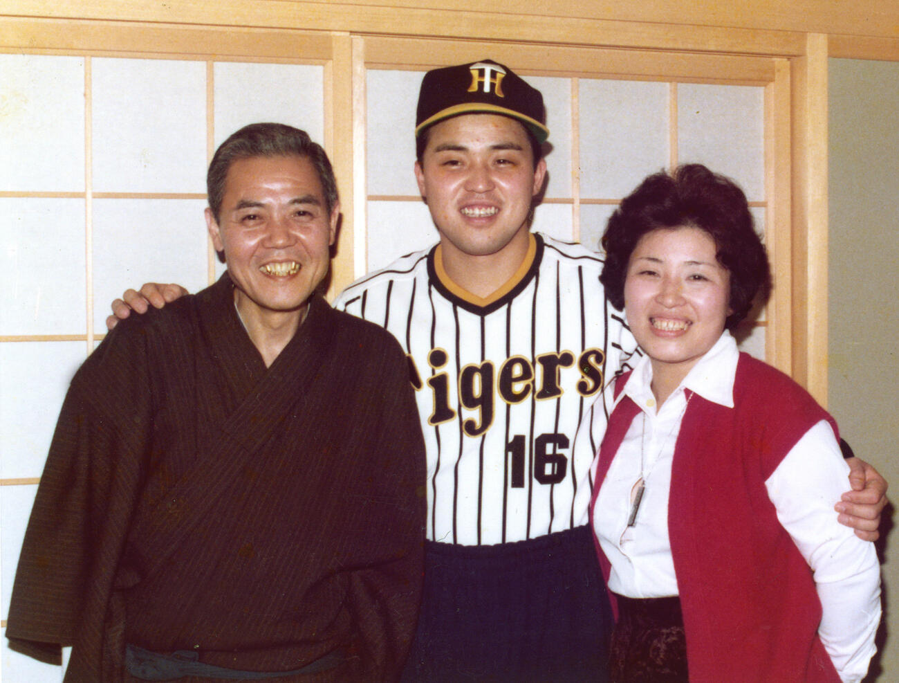 入団会見後にユニホームを着て父勇郎さん（左）、母サカヨさん（右）と記念写真に納まる阪神・岡田彰布（79年12月15日）