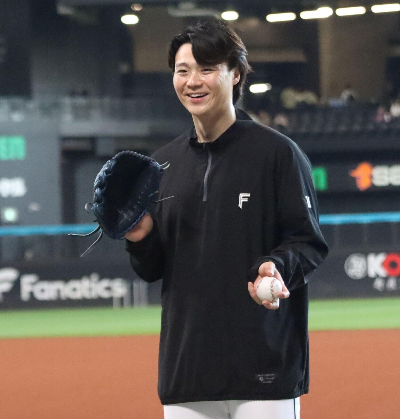 ボールを握り笑顔でスタッフと談笑する日本ハム山崎福也