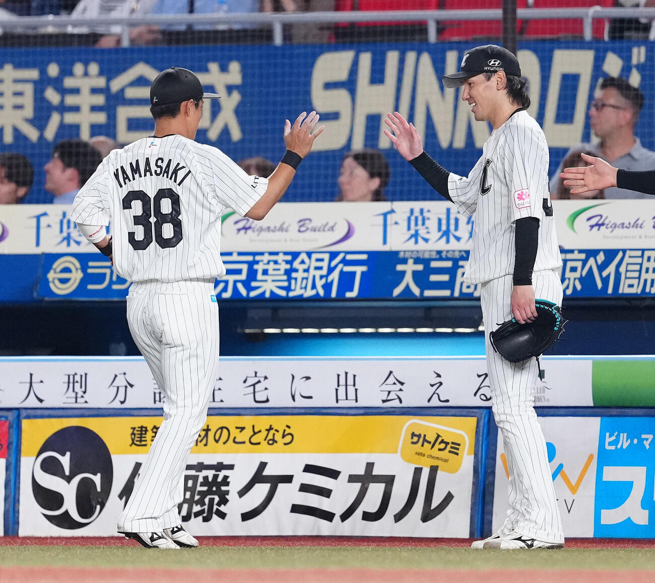 ロッテ対西武　7回表まで無失点に抑え、山崎剛（左）を迎えるロッテ高野脩汰（撮影・鈴木みどり）