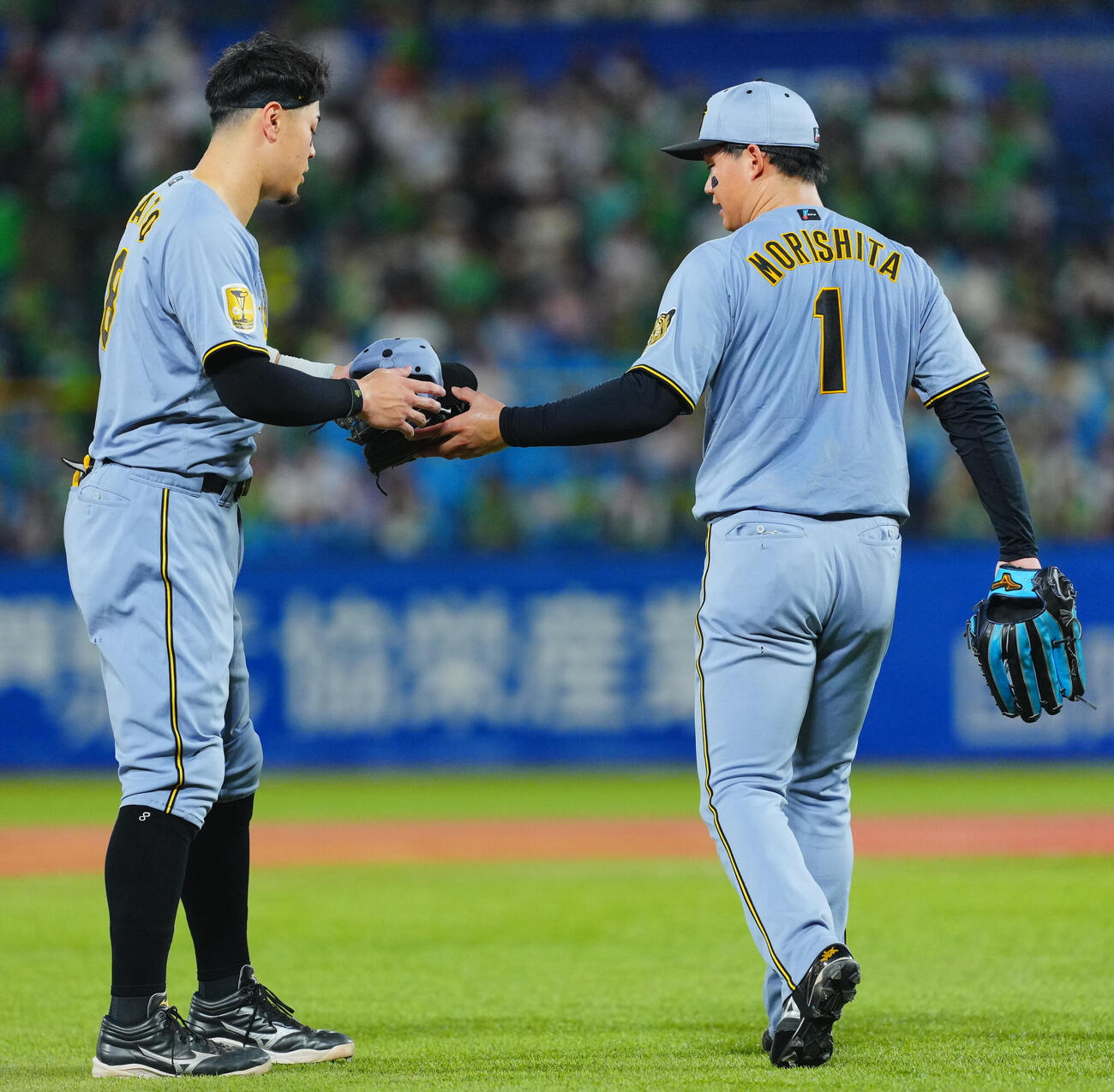 ヤクルト対阪神　4回表阪神2死、右飛に倒れた佐藤輝明（左）は森下翔太から帽子とグラブを受け取り守備位置に就く（撮影・垰建太）
